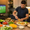 A guy making food using Gulf fruits cut vegetables for match nights